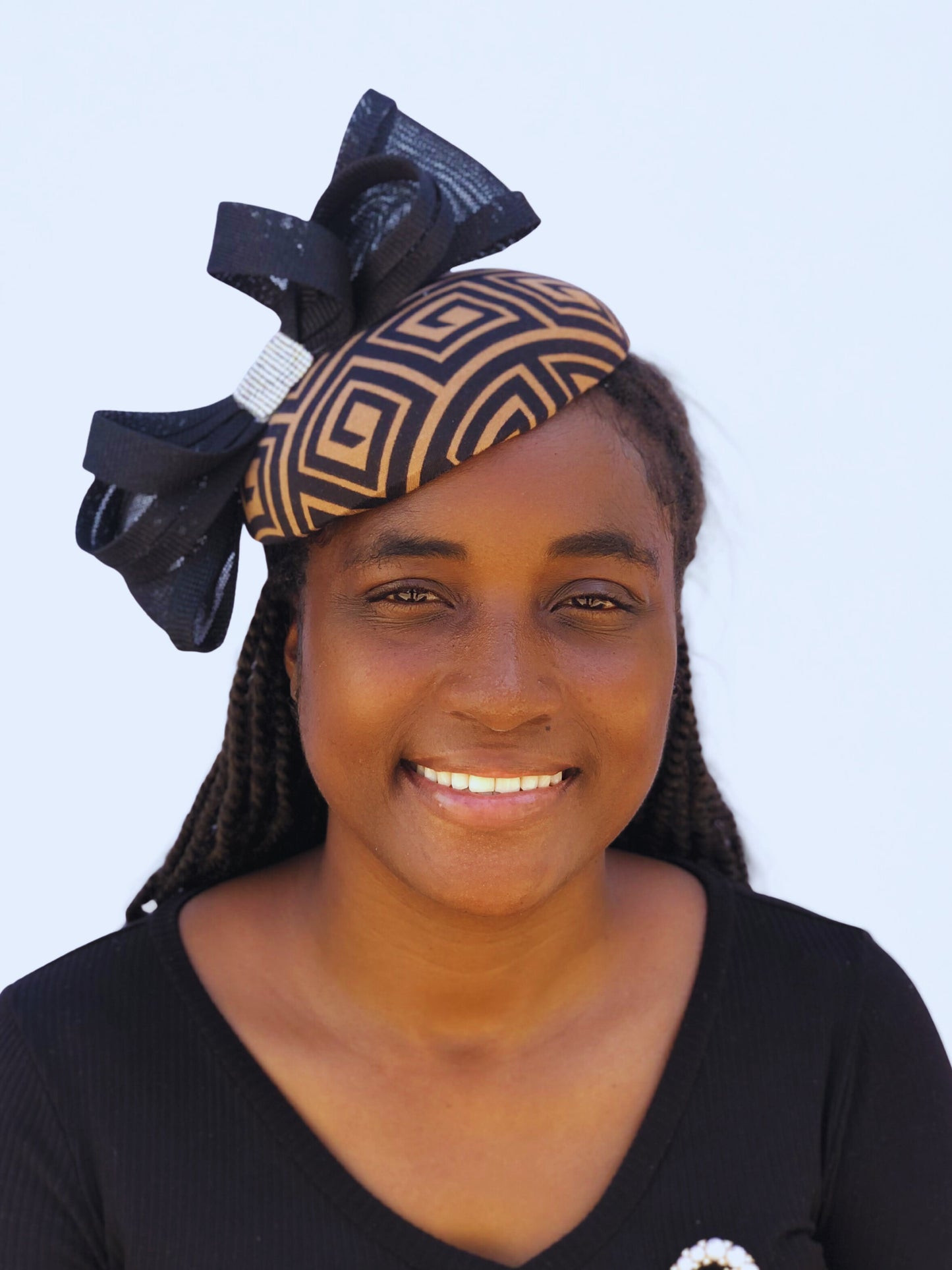 Women’s church fascinator in black and tan with bold bow detail and rhinestone embellishment.