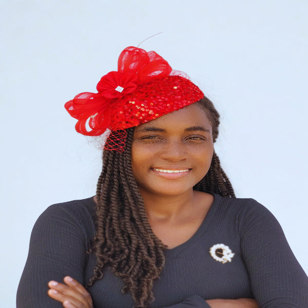 Red sequin fascinator with mesh bow, flower detail, and netting – elegant women’s church hat.