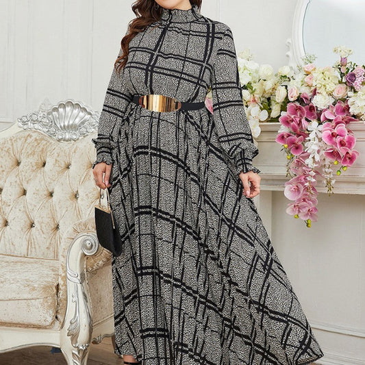 Woman wearing a black and white checkered dress with a gold belt in a decorated room.