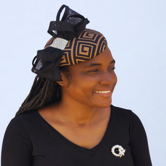 Women’s church fascinator in black and tan with bold bow detail and rhinestone embellishment.