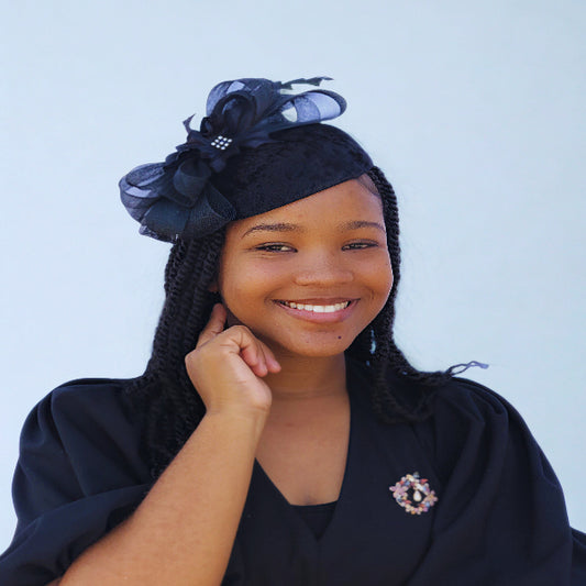 Woman wearing a black headwrap with decorative elements against a light blue background