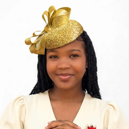 Young girl wearing a gold hat and white dress with a red flower on a white background