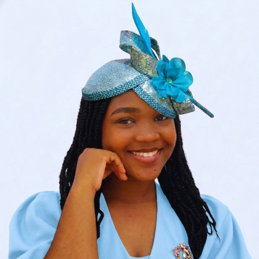 Woman wearing a blue dress with a matching headpiece against a white background