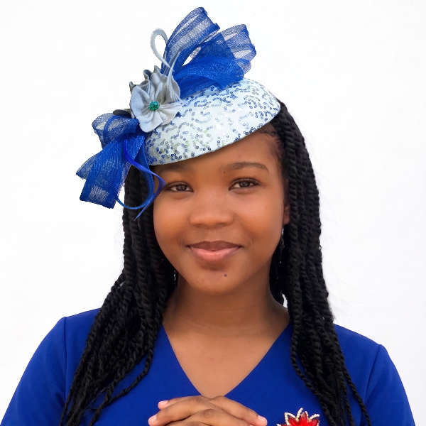 Woman wearing a blue and white decorative headpiece with a blue shirt featuring a red flower design.