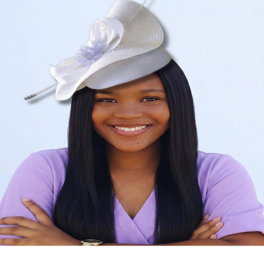 Young girl wearing a white hat with a purple flower against a light blue background