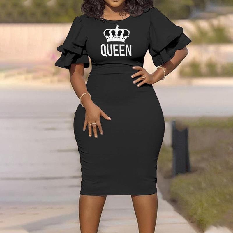 Black dress with 'QUEEN' print on a blurred outdoor background
