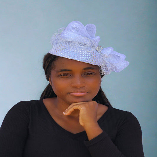 Woman wearing a decorative white headpiece against a light blue background